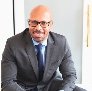 dave davis headshot man sitting in gray suit