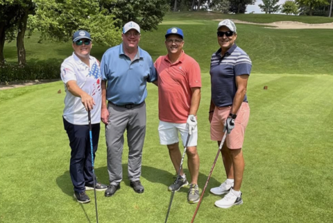 group of men standing on a golf course